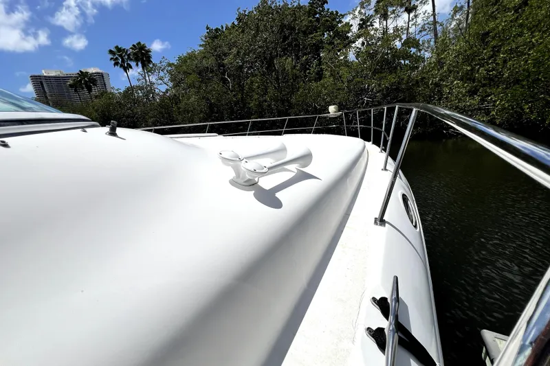 Slide: The Image of 1999 Cruisers Yachts 3870 Esprit on water, surrounded by lush greenery and blue sky. - 40