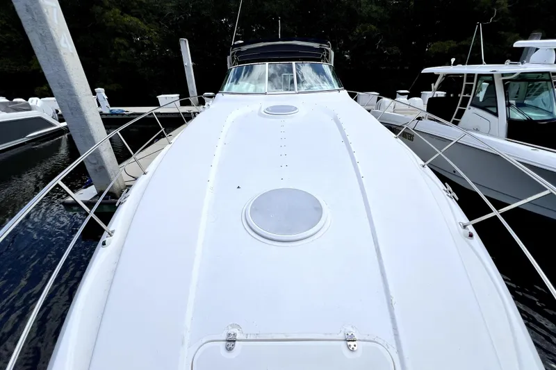Slide: The Image of 1999 Cruisers Yachts 3870 Esprit docked, showcasing sleek white deck and modern design. - 48