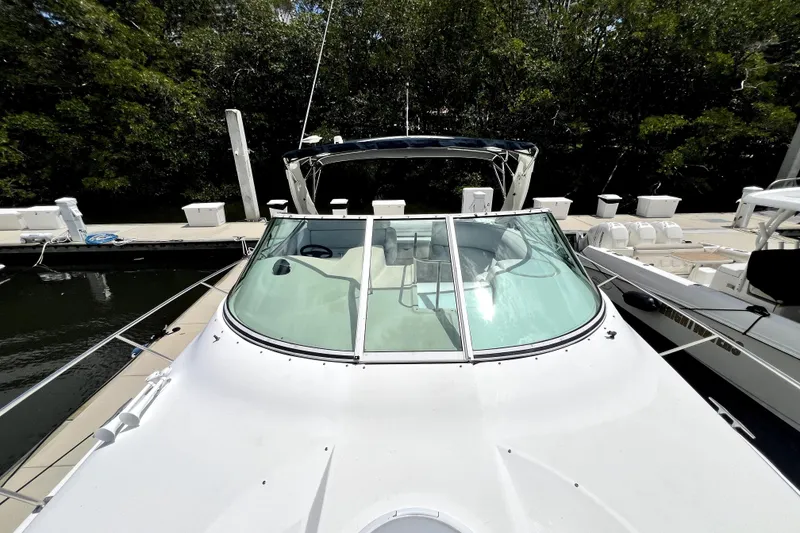 Slide: The Image of 1999 Cruisers Yachts 3870 Esprit docked, showcasing sleek design and spacious deck. - 49