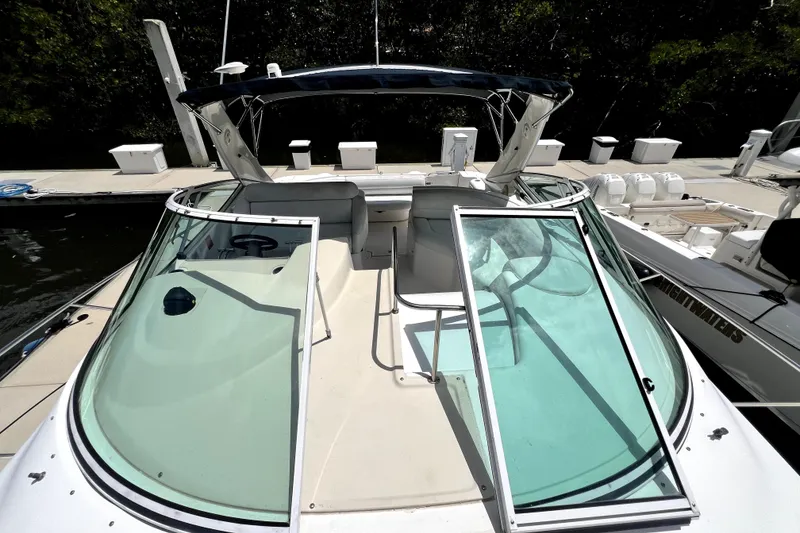 Slide: The Image of 1999 Cruisers Yachts 3870 Esprit docked, showcasing open cockpit and windshield. - 52