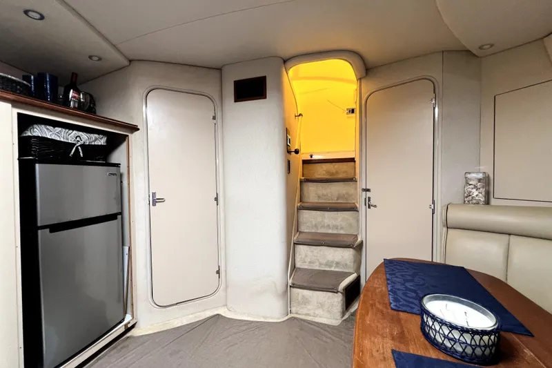 Slide: The Image of Interior of 1999 Cruisers Yachts 3870 Esprit with stairs, fridge, and dining area. - 56