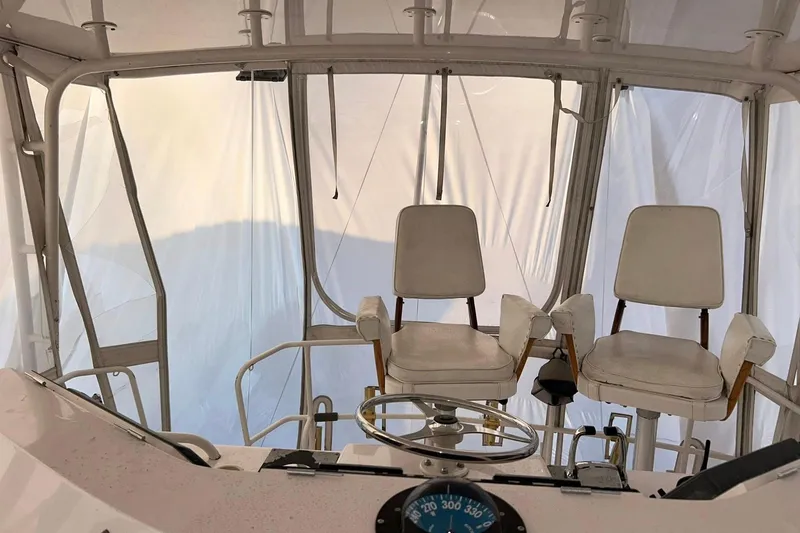 Slide: The Image of Interior view of a 1995 Bertram 43 Convertible yacht cockpit with two white chairs. - 14