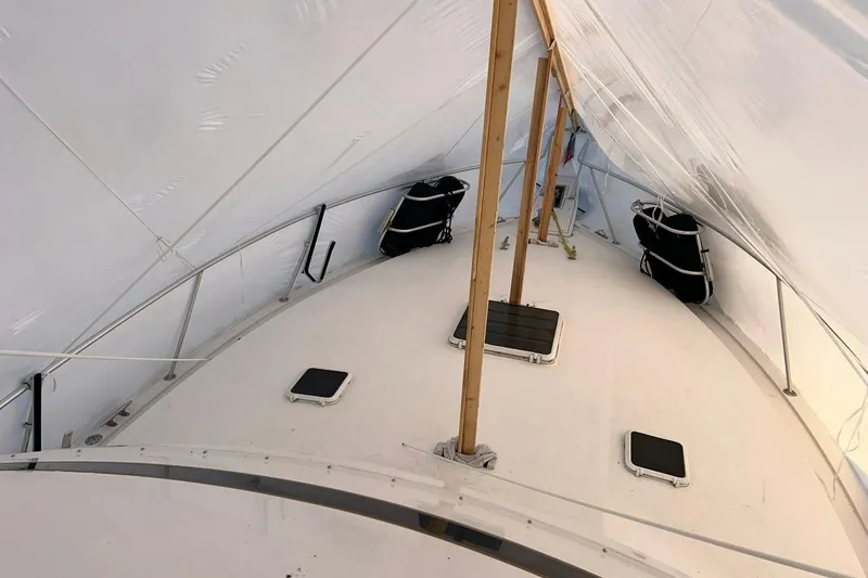 Slide: The Image of Covered deck of a 1995 Bertram 43 Convertible boat, featuring support poles and hatches. - 15