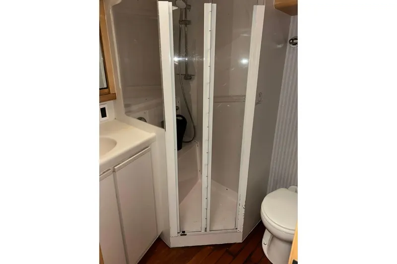 Slide: The Image of Bathroom interior of a 1995 Bertram 43 Convertible yacht, featuring a shower and toilet. - 17