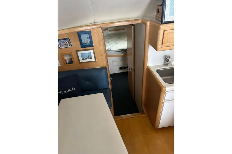 Slide: The Image of Interior of a 1995 Bertram 43 Convertible yacht with cozy seating and framed photos. - 19