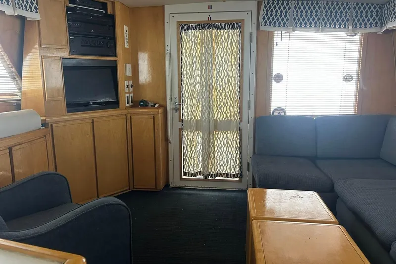 Slide: The Image of Interior of a 1995 Bertram 43 Convertible yacht with cozy seating and entertainment system. - 5