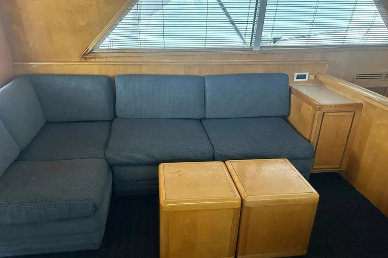 Slide: The Image of Interior of 1995 Bertram 43 Convertible yacht with blue sofa and wooden tables. - 7