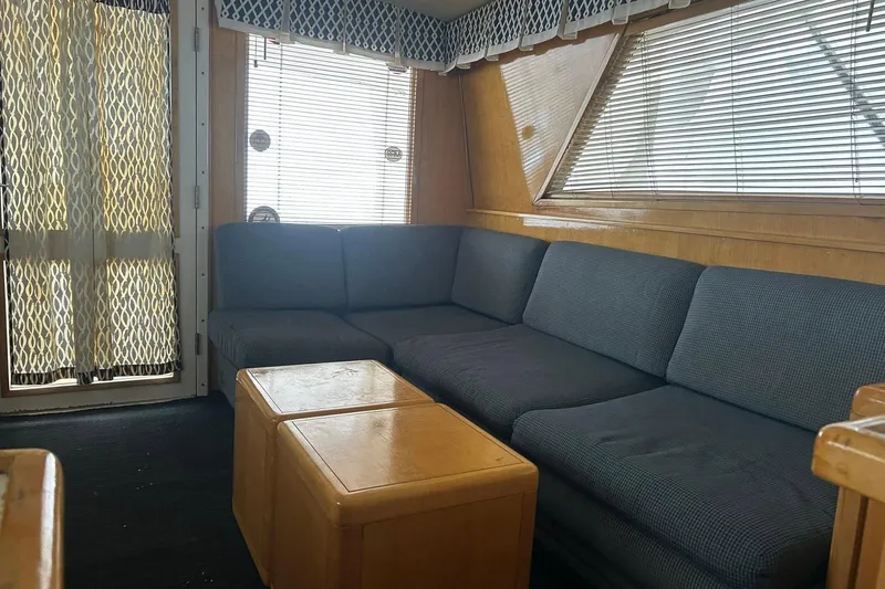 Slide: The Image of Interior of a 1995 Bertram 43 Convertible yacht with blue sofa and wooden accents. - 8