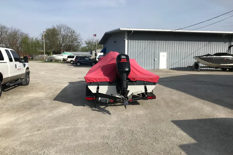 Slide: The Image of Covered 2001 Ranger 217B Cherokee boat with outboard motor in a parking lot. - 10