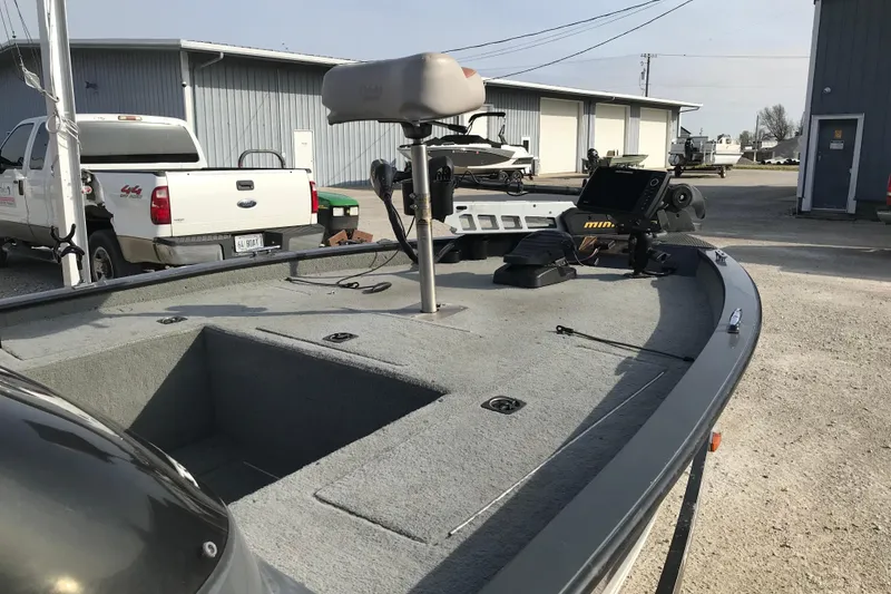 Slide: The Image of 2001 Ranger 217B Cherokee boat with fishing equipment, parked near trucks and buildings. - 19
