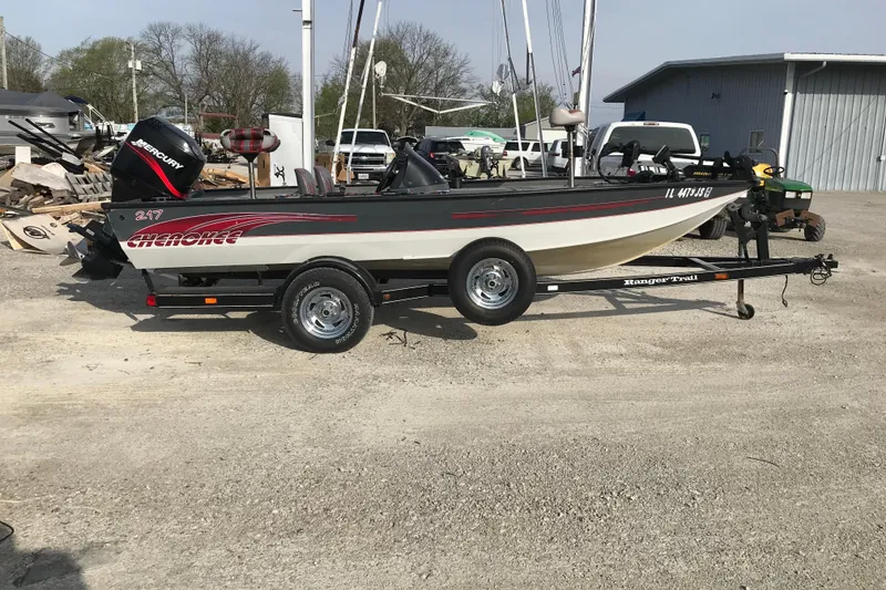 The Image of 2001 Ranger 217B Cherokee boat on trailer, parked outdoors. - 2