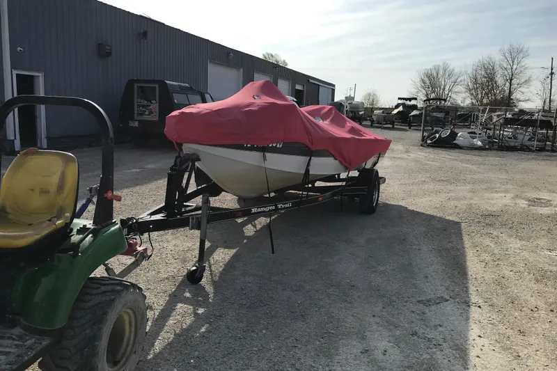 Slide: The Image of A 2001 Ranger 217B Cherokee boat covered in red, on a trailer in a parking lot. - 7