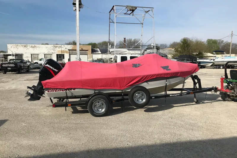 Slide: The Image of 2001 Ranger 217B Cherokee boat with red cover on trailer in outdoor lot. - 9
