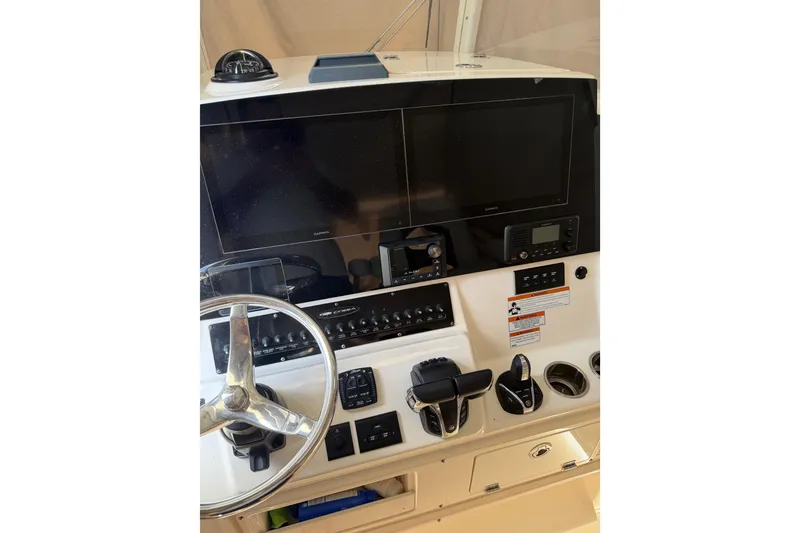 Slide: The Image of 2022 Cobia 320 Center Console helm with dual screens and steering wheel. - 4