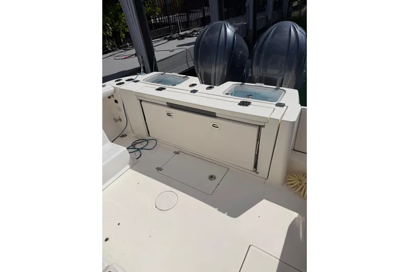 Slide: The Image of 2022 Cobia 320 Center Console boat deck with dual engines and storage compartments. - 6