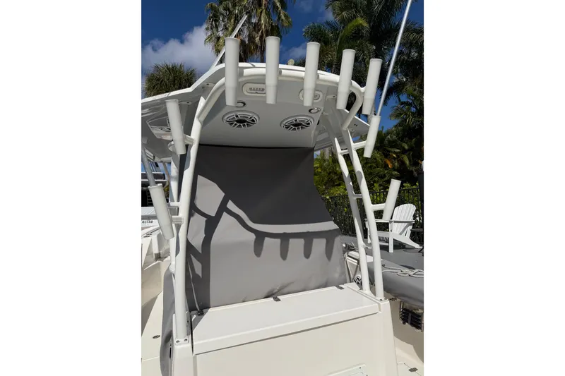 Slide: The Image of 2022 Cobia 320 Center Console boat with rod holders and speakers, set against a tropical backdrop. - 8