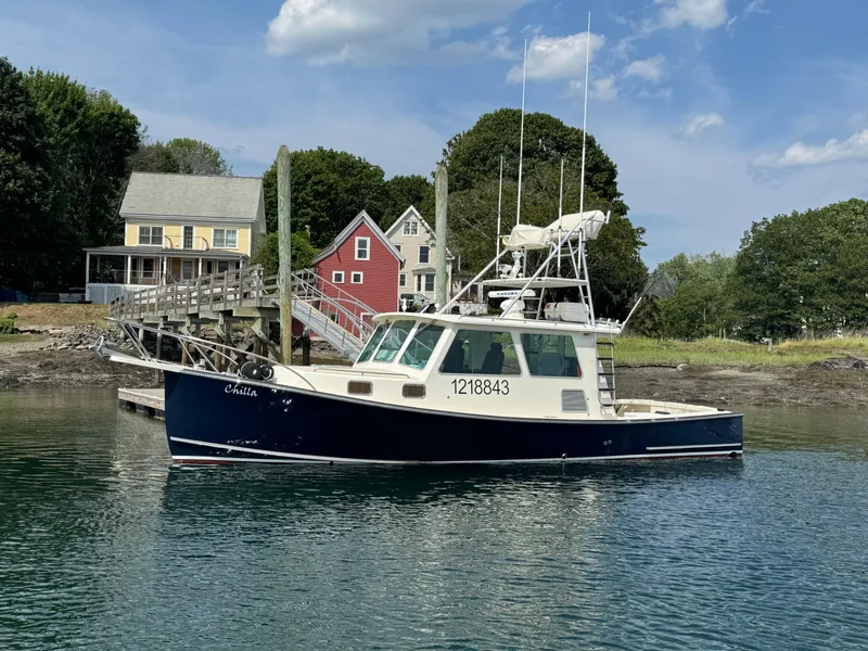 The Image of 2009 Northern Bay 36 boat docked near colorful houses and lush greenery. - 0