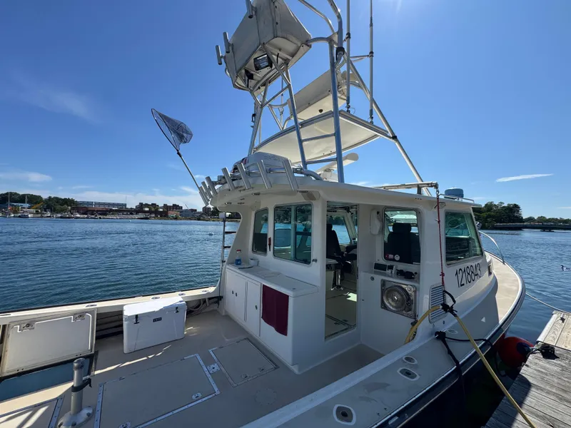 Slide: The Image of 2009 Northern Bay 36 boat docked, featuring a spacious deck and tower under clear blue skies. - 11