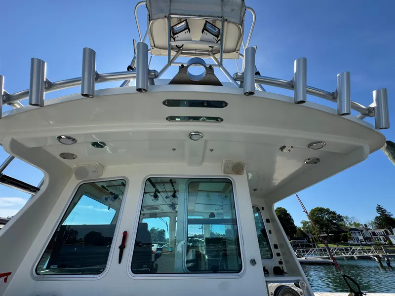 Slide: The Image of 2009 Northern Bay 36 boat with rod holders and cabin windows, docked under clear blue sky. - 27