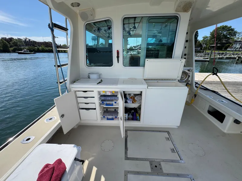 Slide: The Image of Northern Bay 36 boat interior with storage compartments, docked by a scenic waterfront. - 29
