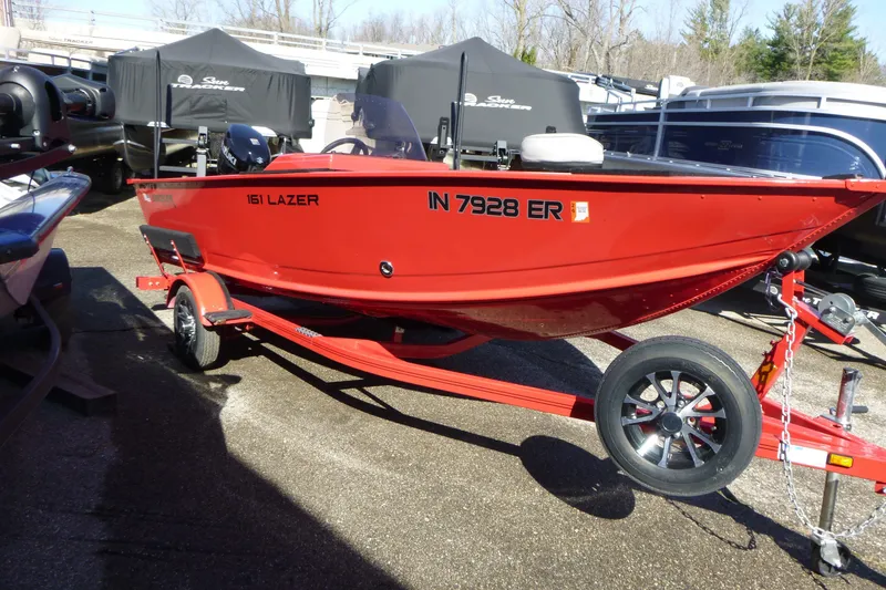 Slide: The Image of Red 2025 Smoker Craft Lazer 161 boat on trailer, parked outdoors. - 3