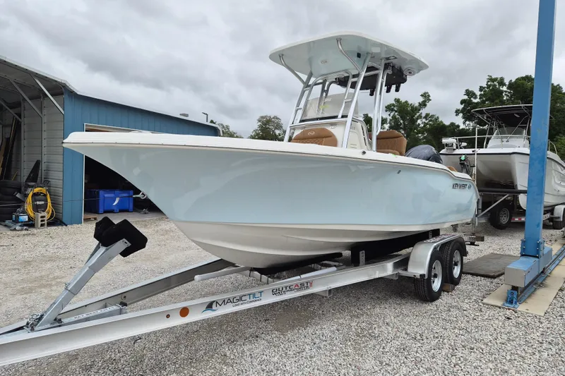 The Image of 2026 Key West 219 FS boat on trailer, parked outdoors near a blue building. - 1
