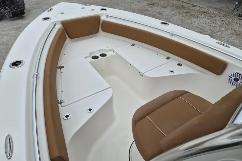 Slide: The Image of 2026 Key West 219 FS boat interior with brown seating and storage compartments. - 13