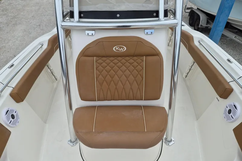 Slide: The Image of 2026 Key West 219 FS boat interior with brown cushioned seating and stainless steel frame. - 16