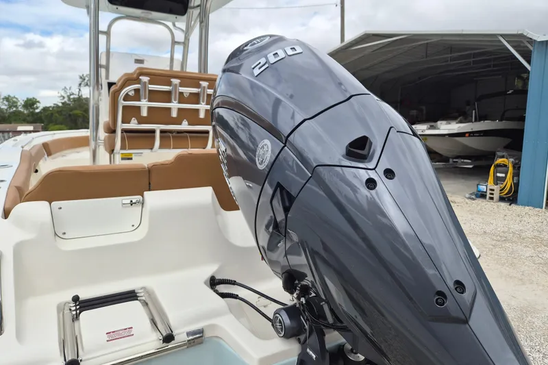 Slide: The Image of 2026 Key West 219 FS boat with powerful 200 HP outboard motor, docked near a shed. - 4