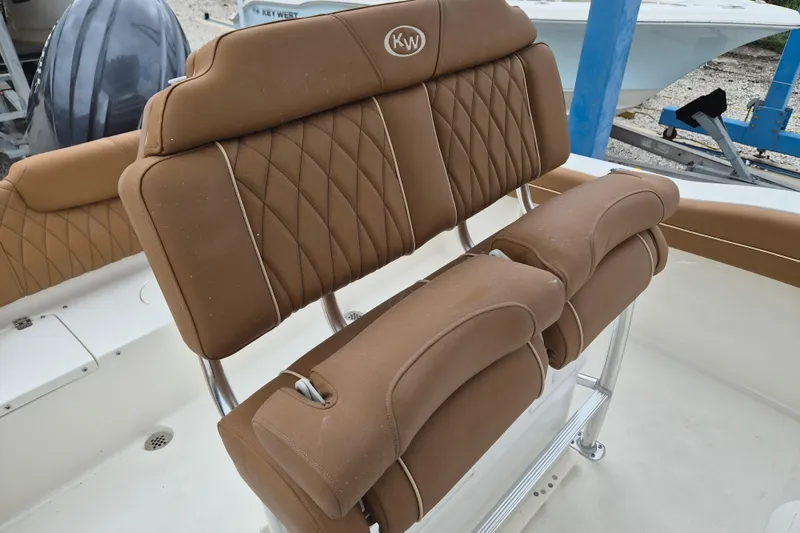 Slide: The Image of 2026 Key West 219 FS boat with tan cushioned seating and stainless steel frame. - 7