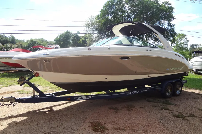 Slide: The Image of 2008 Chaparral 276 SSX boat on trailer, parked outdoors with trees in background. - 11