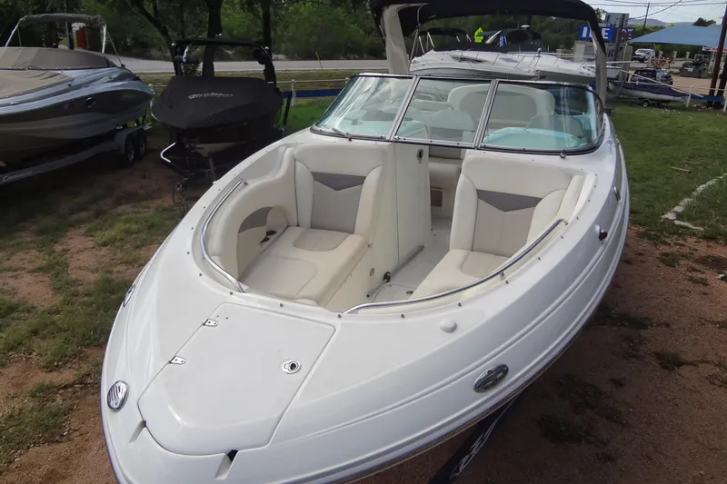 Slide: The Image of 2008 Chaparral 276 SSX boat with spacious seating, parked on grassy area. - 13