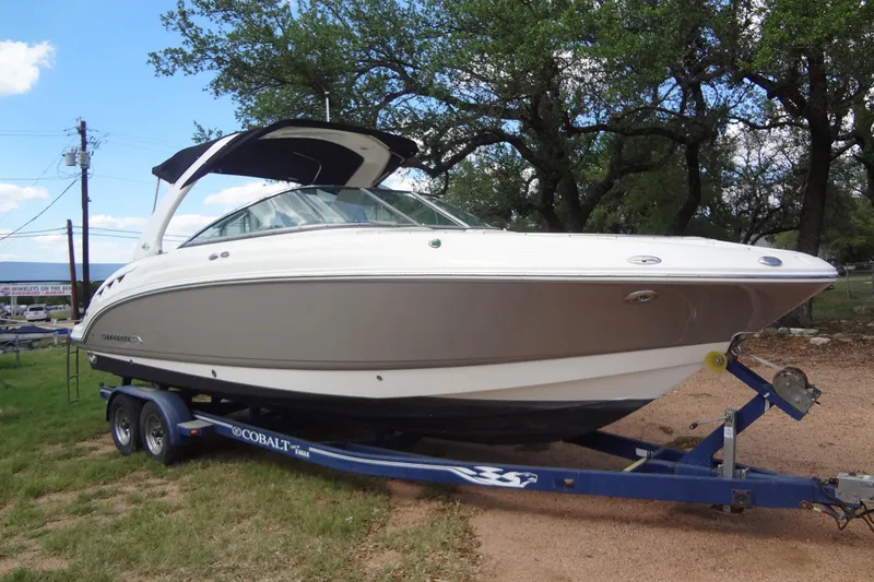 Slide: The Image of 2008 Chaparral 276 SSX boat on trailer, parked outdoors with trees in background. - 5