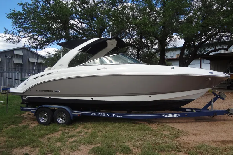 Slide: The Image of 2008 Chaparral 276 SSX boat on trailer, parked outdoors near trees and buildings. - 6