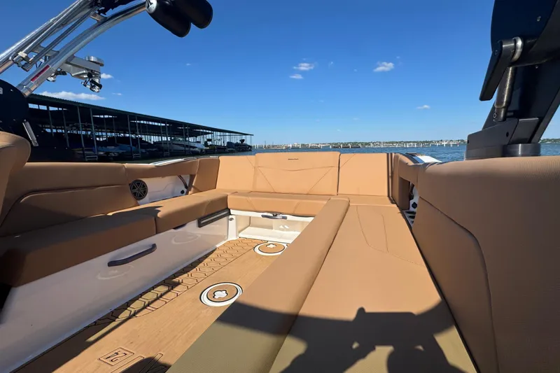 Slide: The Image of 2021 MasterCraft NXT24 boat interior with tan seating and lake view. - 10