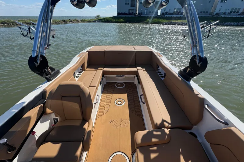 Slide: The Image of 2021 MasterCraft NXT24 boat interior with tan seating and sleek design on the water. - 18
