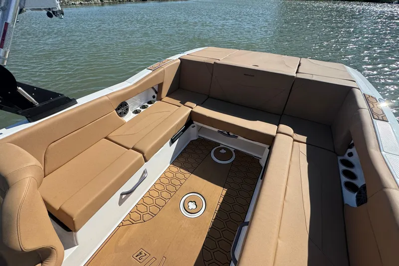 Slide: The Image of 2021 MasterCraft NXT24 boat interior with tan seating and hexagonal floor design. - 19