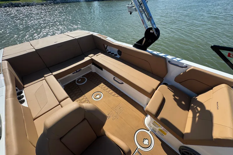 Slide: The Image of 2021 MasterCraft NXT24 boat interior with tan seating and lake view. - 20