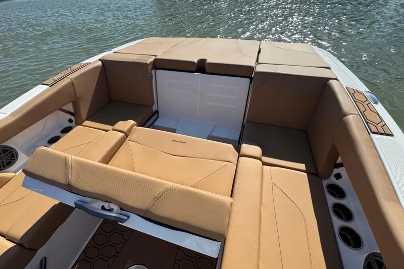 Slide: The Image of 2021 MasterCraft NXT24 boat interior with tan seating, on a sunny day. - 21