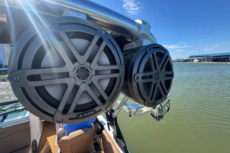 Slide: The Image of Speakers on a 2021 MasterCraft NXT24 boat, with a scenic waterfront view. - 27