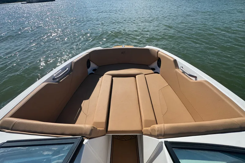 Slide: The Image of 2021 MasterCraft NXT24 boat with tan seating, on calm water. - 7