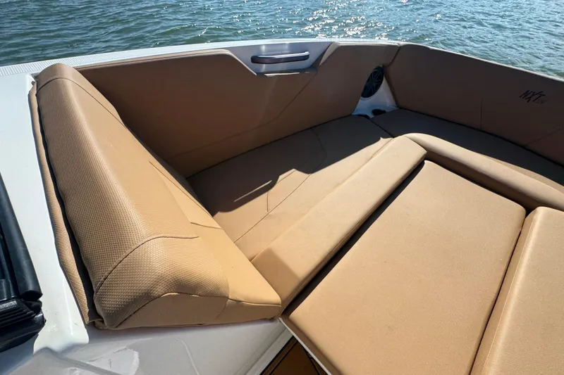 Slide: The Image of 2021 MasterCraft NXT24 boat interior with tan seating, on water. - 8