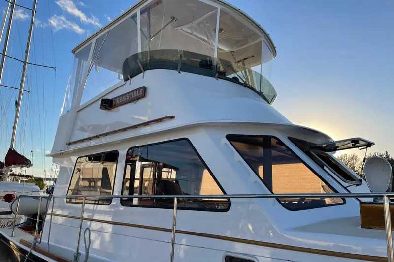 Slide: The Image of 1987 Lyman-Morse Hunt 42 yacht docked, featuring sleek design and upper deck. - 13