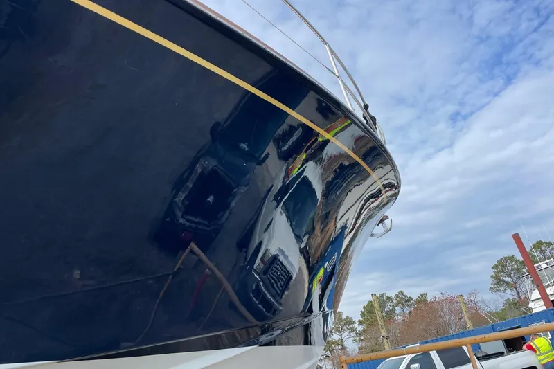 Slide: The Image of 1987 Lyman-Morse Hunt 42 yacht with reflective hull, parked outdoors under cloudy sky. - 19