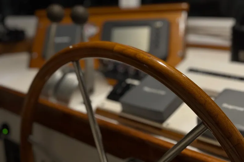 Slide: The Image of Close-up of Lyman-Morse Hunt 42 yacht helm, featuring wooden steering wheel and control panel. - 25