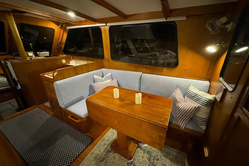 Slide: The Image of Cozy interior of 1987 Lyman-Morse Hunt 42 yacht with wooden dining area and cushions. - 36