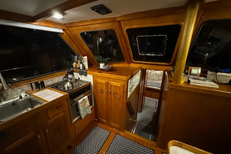Slide: The Image of Interior of 1987 Lyman-Morse Hunt 42 yacht with wooden cabinetry and kitchen amenities. - 43