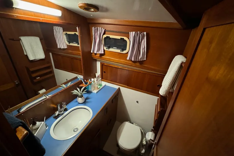 Slide: The Image of 1987 Lyman-Morse Hunt 42 yacht bathroom with wood paneling and blue countertop. - 44