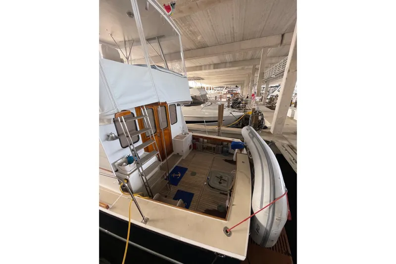 Slide: The Image of 1987 Lyman-Morse Hunt 42 yacht docked in a covered marina, featuring a spacious deck. - 58