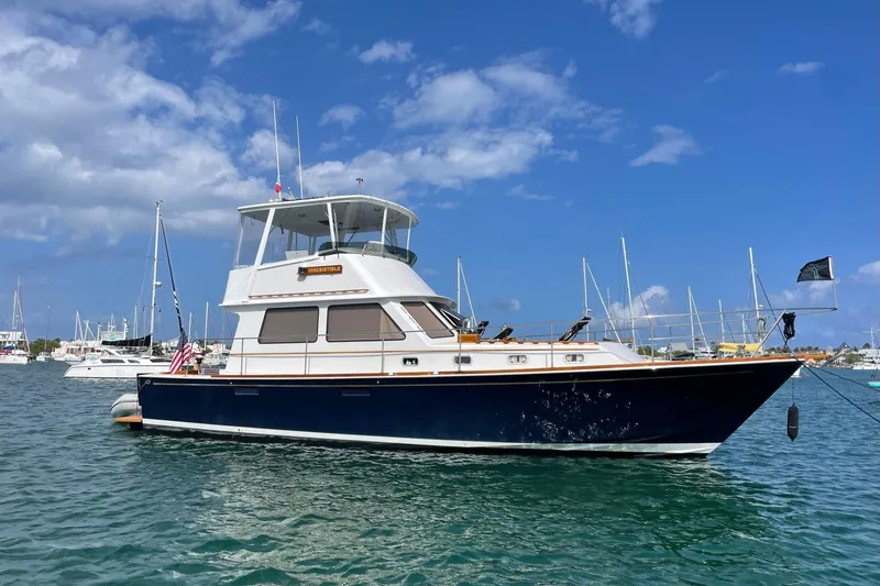 Slide: The Image of 1987 Lyman-Morse Hunt 42 yacht anchored in a sunny marina with blue skies. - 8